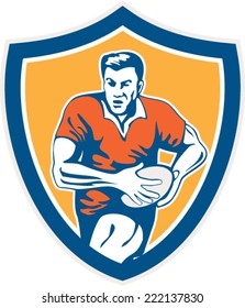 Illustration of a rugby player holding ball running charging set inside shield crest on isolated background done in retro style. 