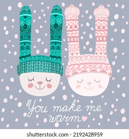 Illustration of two attractive cute rabbits heads in winter hats near each other on snowflakes background with You Make Me Warm inscription. For card, teenager clothes print.