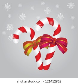 Illustration of two candy canes with bows on gray background.