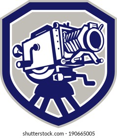 Illustration of a vintage movie film camera viewed from low angle front set inside shield crest shape done in retro  style.