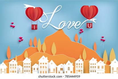 
illustrations of love and valentine's day. there is a red air balloon as a symbol of love. housing and beautiful hills. paper art design