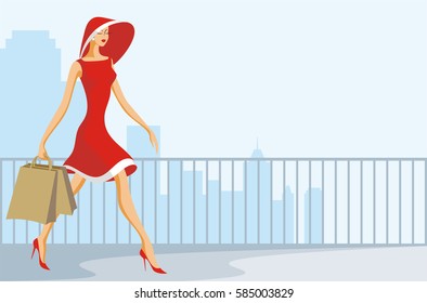 The image of the beautiful young woman with purchases against the background of a city landscape