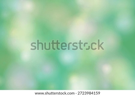 The image depicts a blurred background with a predominant green hue. The image is out of focus, creating a soft and dreamy atmosphere with various shades of green and hints of white and blue. The overall effect is calming and serene, evoking a sense of nature and tranquility.