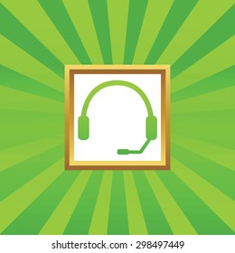 Image of headset in golden frame, on green abstract background