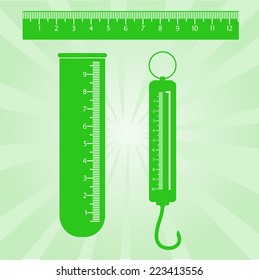Image of a ruler, test tube, scales of green color.