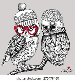 Image of two owls in knitted hats, glasses on a branch. Vector illustration.