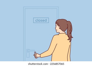 Indecisive woman pulls hand to door with inscription closed stands with back to screen. Girl is discouraged and does not know what to do after store is closed due to bankruptcy