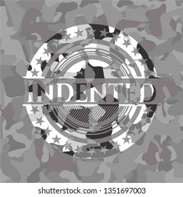 Indented written on a grey camouflage texture