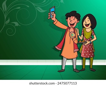 Indian Brother and Sister Taking Selfie After Celebrating Raksha Bandhan Festival on Green Background with Copy Space.