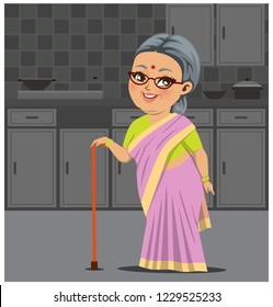 An Indian fat old happy grandmother wearing a saree is standing in a kitchen with a stick in her hand for support.