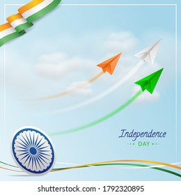 Indian Independence Day with Indian Tri colors flying Paper Jet Planes with Trails, Ashoka wheel, National Indian Flag Tricolours wave on Cloudy Blue Background.