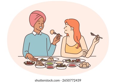 Homem indiano e mulher caucasiana estão sentados à mesa de jantar saboreando cozinha tradicional indiana com especiarias. Casal multicultural jantar juntos em restaurante degustando pratos nacionais