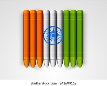 Indian Republic Day celebration with glossy wax crayons in national flag colors and Ashoka Wheel on grey background.