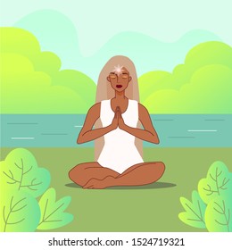 Indian woman in the lotus position in the park. Yoga in the park
