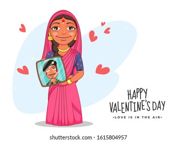 Indian Woman Showing Her Husband Photo Frame with Red Hearts on the Occasion of Happy Valentine's Day, Love is in the air concept.