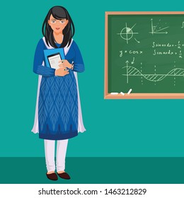 Indian woman teacher in front of a greenboard