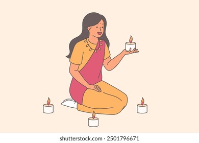 Indian woman in traditional dress holds candles, sitting on knees and doing buddhist ritual at Diwali festival. Indian girl praying to god or meditating to achieve mental balance and harmony