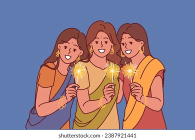 Indian women with sparklers celebrate Diwali festival, dressed in traditional national clothes. Three girls from india participating in Diwali event and wishing to introduce you to indian culture