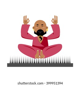 Indian yogi sits on spike. nirvana Meditation. Man practicing yoga exercises. Bald guy with beard meditates
