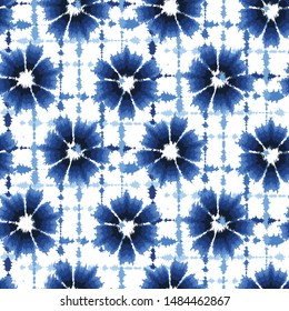 Indigo blue shibori tie dye sunburst flower circle background. Seamless pattern on white background. Japanese style batik floral textile. Variegated for summer fashion swatch.