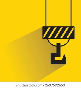industrial crane hook icon with drop shadow on yellow background