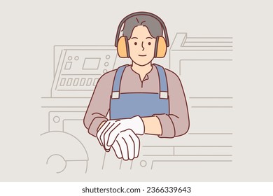 Industrial factory worker man in headphones protecting ears from loud sounds stands near milling machine. Guy industrialist makes career in woodworking factory or building materials production