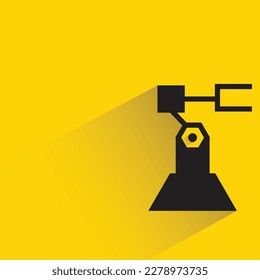 brazo robótico industrial con sombra sobre fondo amarillo