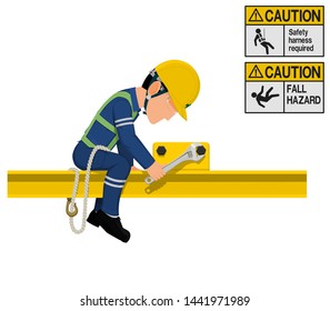 An industrial worker with safety harness is working at height
