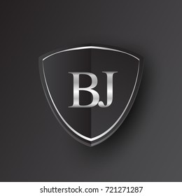 Initial logo letter BJ with shield Icon silver color isolated on black background, logotype design for company identity.