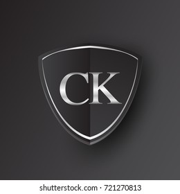 Initial logo letter CK with shield Icon silver color isolated on black background, logotype design for company identity.