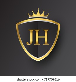 Initial logo letter JH with shield and crown Icon golden color isolated on black background.