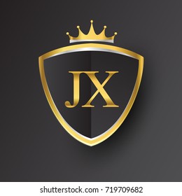 Initial logo letter JX with shield and crown Icon golden color isolated on black background.