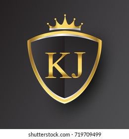 Initial logo letter KJ with shield and crown Icon golden color isolated on black background.
