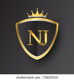 Initial logo letter NJ with shield and crown Icon golden color isolated on black background, logotype design for company identity.