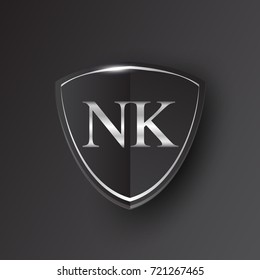 Initial logo letter NK with shield Icon silver color isolated on black background, logotype design for company identity.