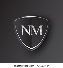 Initial logo letter NM with shield Icon silver color isolated on black background, logotype design for company identity.