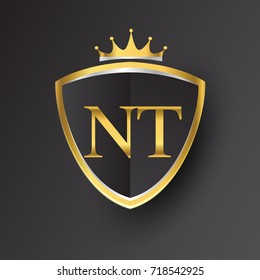 Initial logo letter NT with shield and crown Icon golden color isolated on black background, logotype design for company identity.