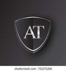 Initial logo letter AT with shield Icon silver color isolated on black background, logotype design for company identity.