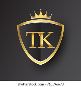 Initial logo letter TK with shield and crown Icon golden color isolated on black background, logotype design for company identity.