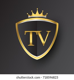 Initial logo letter TV with shield and crown Icon golden color isolated on black background, logotype design for company identity.