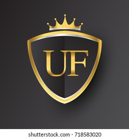 Initial logo letter UF with shield and crown Icon golden color isolated on black background, logotype design for company identity.