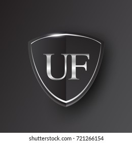 Initial logo letter UF with shield Icon silver color isolated on black background, logotype design for company identity.