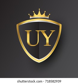 Initial logo letter UY with shield and crown Icon golden color isolated on black background, logotype design for company identity.