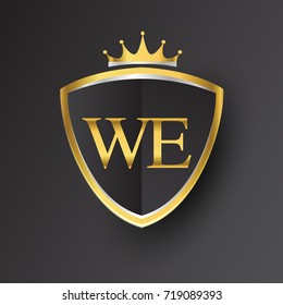 Initial logo letter WE with shield and crown Icon golden color isolated on black background, logotype design for company identity.