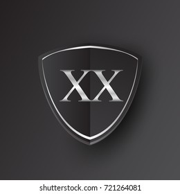 Initial logo letter XX with shield Icon silver color isolated on black background, logotype design for company identity.