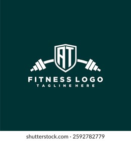 AT initial monogram for fitnes or gym logo with creative shield and barbell design