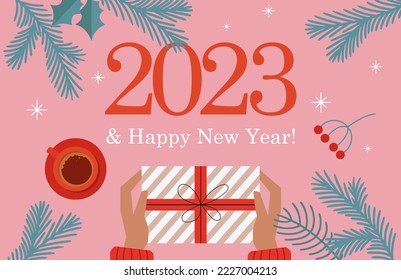 inscription 2023 and Happy New Year against the background with spruce branches with stars a cup of coffee and hands holding a gift