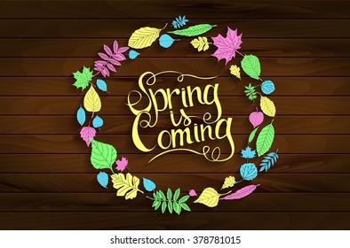 Inscription Spring is coming on wooden background in a frame of colored leaves. Hand draw, vector illustration. Graphic design.