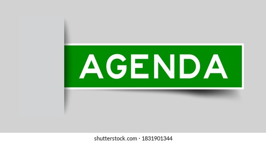 Inserted green color label sticker with word agenda on gray background