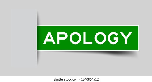 Inserted green color label sticker with word apology on gray background